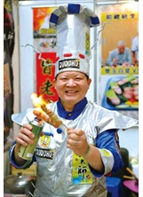 穿著招牌「太空廚師裝」的廖盛芳大展廚藝。（圖片提供／臺南市榮服處）之照片