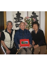 民國一○○年七月，馬蘭榮家輔導員劉興華（左），訪視住在廣西省桂林市的榮民文其揚（中）夫婦，並代表輔導會曾主委致贈禮品。之照片