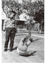 作者（左）的小弟梁加樂在八○二眷村草地上翻跟斗。（圖片提供／梁聖樂）之照片