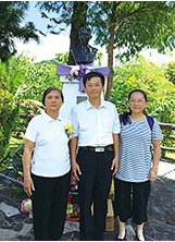 作者張立何（中）與母親（左）、胞妹（右）於父親張箭老師逝世四十周年紀念日在銅像前合影。（圖／張立何）之照片