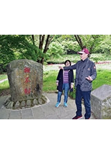 主任委員（右）與搬不動的武陵農場巨石。（記者林建榮／攝影）之照片