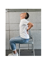 軀幹伸展運動 ˙坐於椅上，雙手置於腰後方，軀幹向後伸展同時頭向後仰並挺胸，維持10～30秒。之照片