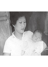 作者陳建華的母親抱著剛滿月、模樣可愛討喜的他。（圖／陳建華）之照片