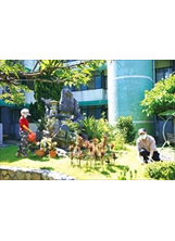 住在八德榮家的榮民李正軒、陳劭華伉儷，在安養中心花園照顧花木，怡然自樂。（圖／八德榮家）之照片