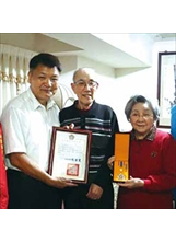 蔣老將軍（中）捐贈500萬元，李副主委（左）頒發榮光獎章，感謝蔣老將軍伉儷的善念。之照片