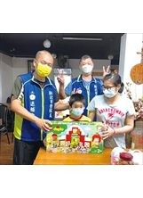 志工隊長陳欣華（左）代表贈送鞠小弟樂高積木玩具組，讓他們母子露出久違的笑容。（圖／新北市榮服處）之照片