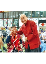 張騰龍會長（右）為長輩獻上佳節祝福，佳里榮家王小旺爺爺（左）收下紅包，笑著比ya。（圖／佳里榮家）之照片