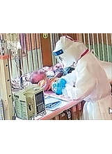 中榮負壓隔離病房中，護理師穿著防護衣照護Omicron確診小病童。（圖／中榮）之照片
