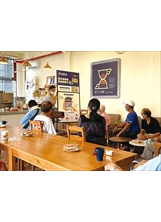 桃園榮家在「時光•逆齡咖啡館」放置大型介紹看板，由工作人員向長輩說明如何申辦數位榮福卡。（圖／桃園榮家）之照片