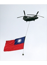 CH-47SD契努克直升機吊掛巨幅國旗，通過總統府上空。（圖／本刊編輯部）之照片
