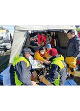 北榮醫師王則堯（藍頭巾者）、楊淑娟（中）在土耳為救難人員療傷。（圖／輔導會）之照片