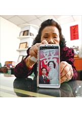 朱鸞女士拿出手機，展示當年的結婚照，憶起和先生共度三十五年歲月，她不禁紅了眼眶。（圖／林建榮）之照片