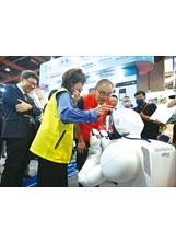 主委在博覽會中，與板橋榮家導入的機器人「樂樂」趣味互動。（圖／林建榮）之照片