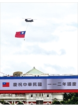 陸軍CH-47SD運輸直升機吊掛巨幅國旗，通過總統府前，為國家慶典增添光輝。（圖／林建榮）之照片