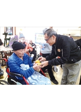 白河榮家主任黃瑞鵬（右）將茂谷柑親手交給住民長輩。（圖／白河榮家）之照片
