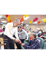 陳玲基金會李棟樑董事長（左）親切致贈慰問金予105歲人瑞方胡老先生（前右）。（圖／八德榮家）之照片