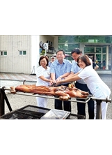 肉香四溢，埔里分院同仁忙著分切烤乳豬，以分享長輩。（圖／中榮埔里分院）之照片