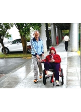 家屬陪伴失智長輩騎輪椅腳踏車，開心遊板橋榮家家區。（圖／板橋榮家）之照片