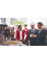 輔導會曾金陵主任委員（右二）視察嘉年華會園遊會攤位，桃園縣榮服處處長張占奎（右一）推薦曾主委享用熱騰騰的炒米粉。之照片