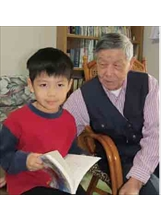 湯為伯（右）看著愛念書的小外孫，感到十分欣慰。之照片