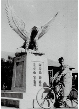 民國四十七年，吳鍾珍擔任空軍四聯隊通信修護分隊電子官時，在第四大隊「志開大樓」八一四「戰鷹塑像」前留影。之照片