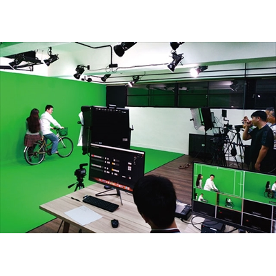 學員在虛擬攝影棚的綠幕前，練習拍攝手法與影像效果。（圖／職訓中心）