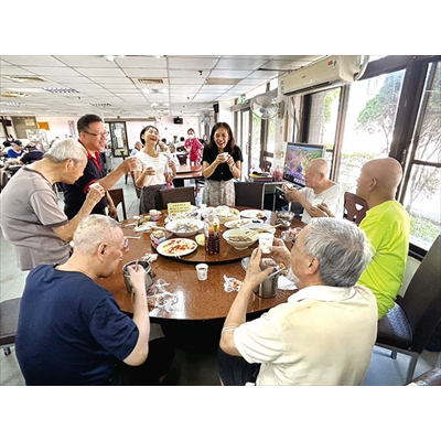 八德榮家百匯宴中，副主任陳小慈逐桌向住民敬茶同歡。（圖／八德榮家）